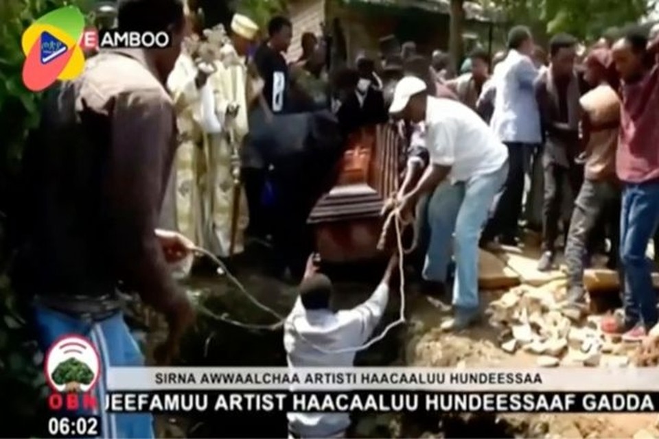 Videostill van het moment dat de kist waarin het lichaam van de vermoorde Ethiopische zanger Hachalu Hundessa ligt in het graf wordt gehesen. 