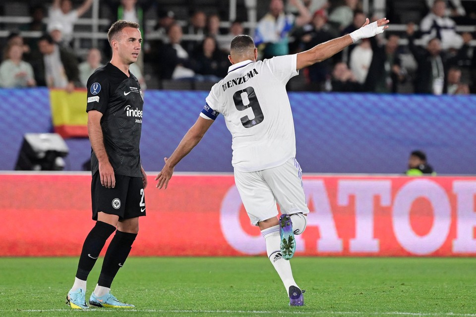 Mario Götze kijkt toe hoe Karim Benzema juichend wegrent. 