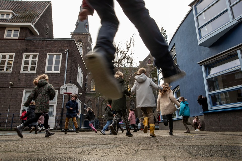 Kinderen op de speelplaats bij de blauwe school in Wyck. 