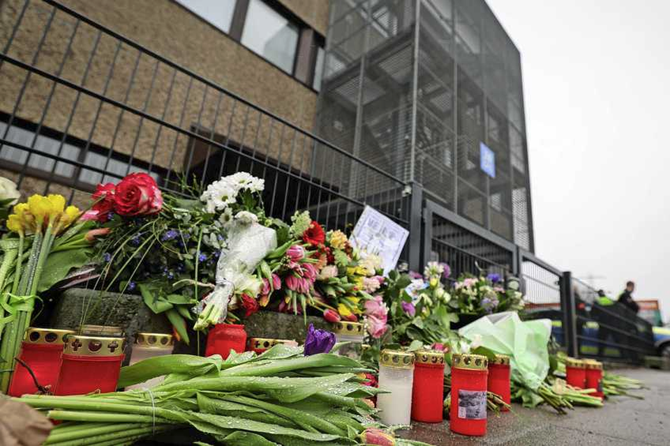 Bloemen en kaarsen voor het gebouw waar de slachting plaatsvond.