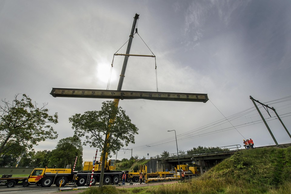 Het nieuwe brugdeel van de spoorbrug Dr Nolenslaan wordt ingehesen. 