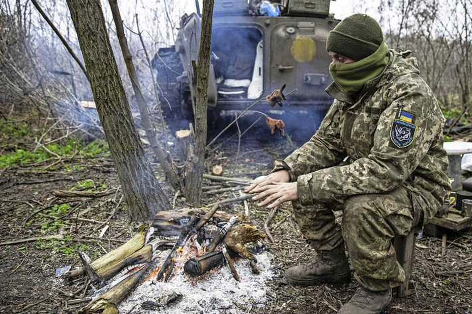 Een Oekraïense soldaat probeert zich op te warmen in de kou. 