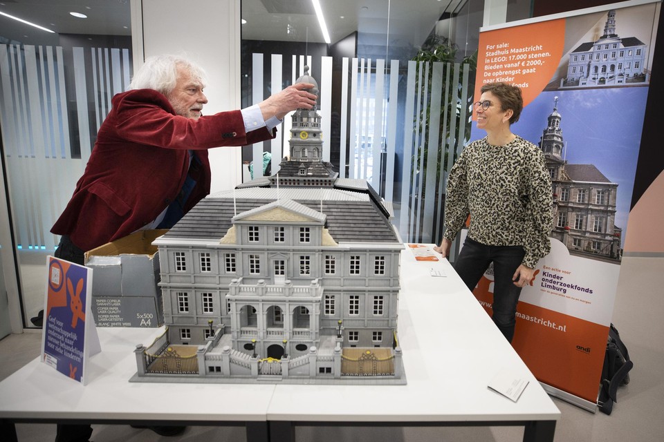 Aldert Dreimüller zet onder toeziend oog van Linda Rutten de toren op zijn Lego-stadhuis.