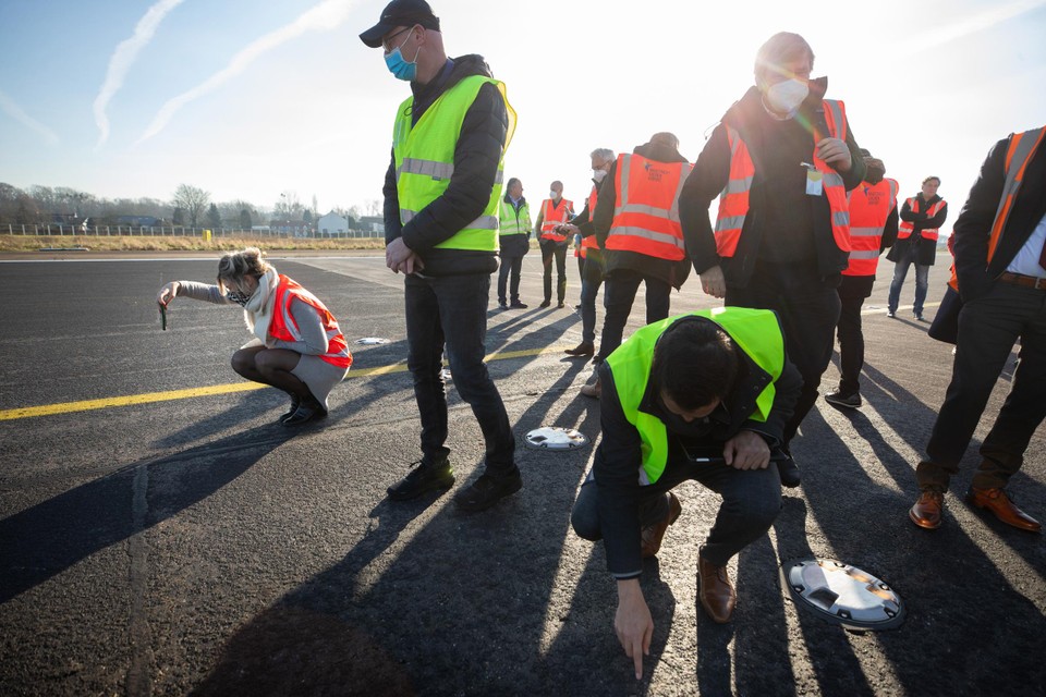 Statenleden bekijken tijdens een werkbezoek de start- en landingsbaan van luchthaven Maastricht Aachen Airport.  