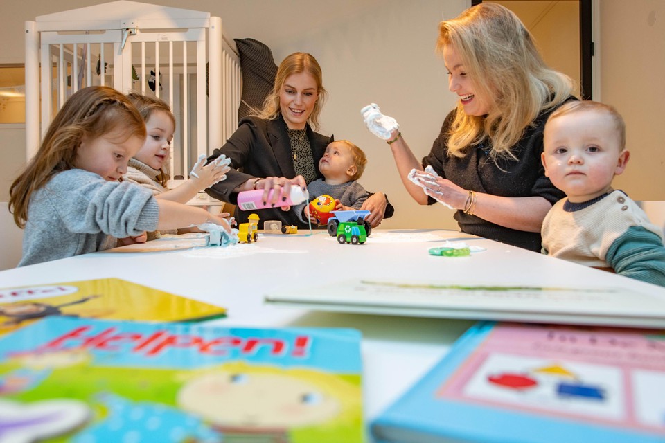 Miré (midden) en Fleur doen een educatief spel met de kinderen in hun eigen kinderopvang.