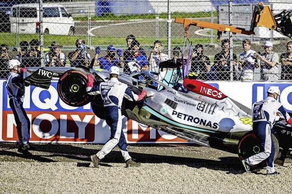 De auto van Lewis Hamilton wordt weggesleept na zijn crash. 