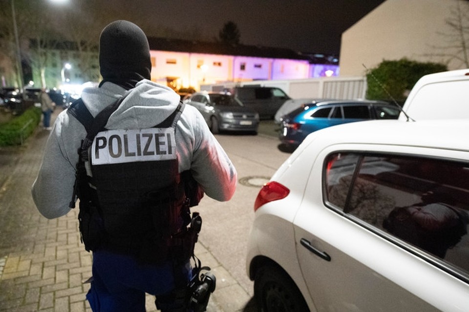 Een Duitse politieman staat op wacht bij de bar waar verschillende mensen werden doodgeschoten.