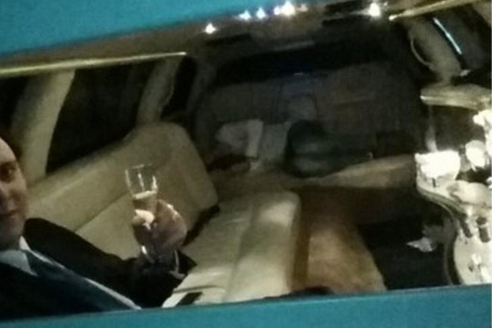 Ruben Coenraad met een glas champagne in de limousine. Op de achtergrond slaapt een andere feestvierder zijn roes uit.