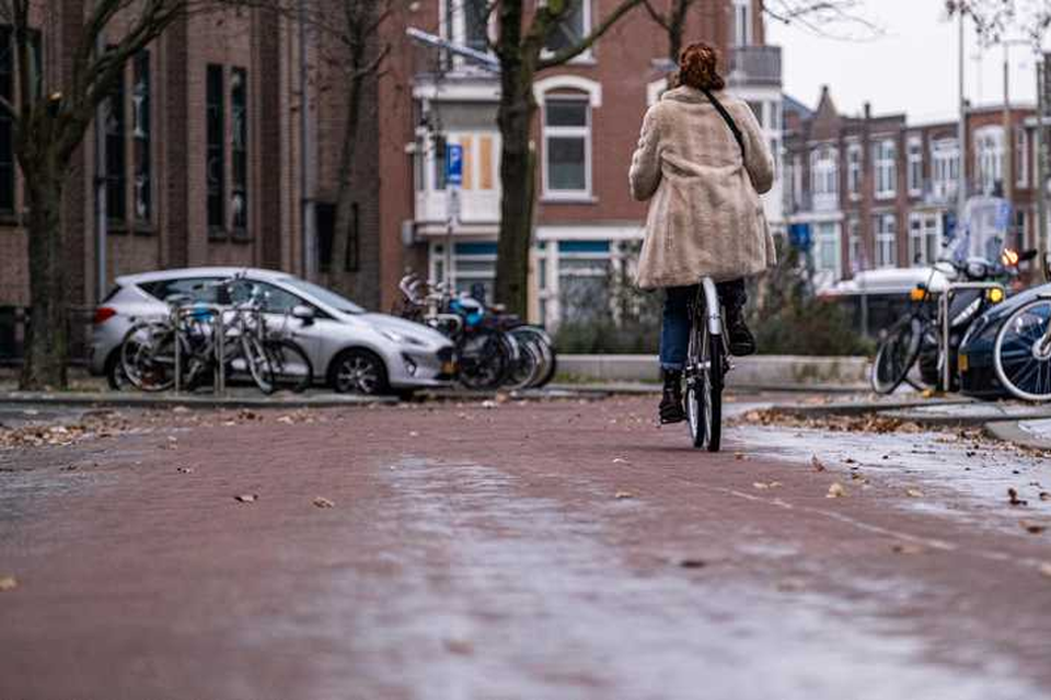 Een vrouw fietst over een gladde weg.