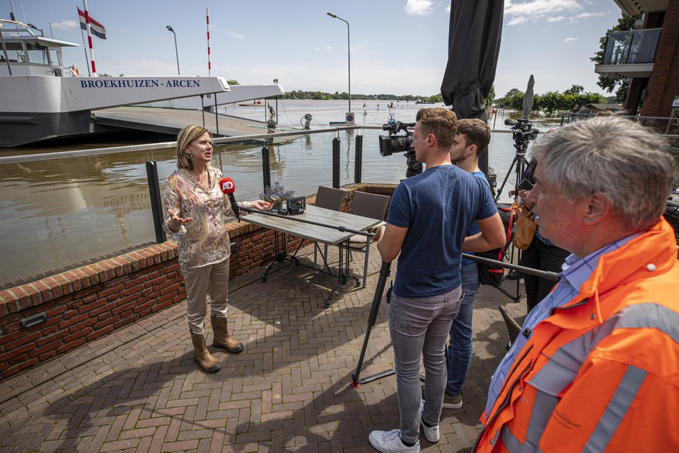 Dijkgraaf Patrick van der Broeck (rechts in oranje jas) kijkt toe als toenmalig minister Cora van Nieuwenhuizen de pers te woord staat tijdens de waterramp afgelopen zomer.  