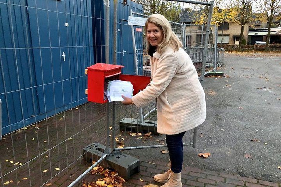 Burgemeester Nicole Ramaekers haalt de brievenbus met de enquêteformulieren leeg. 