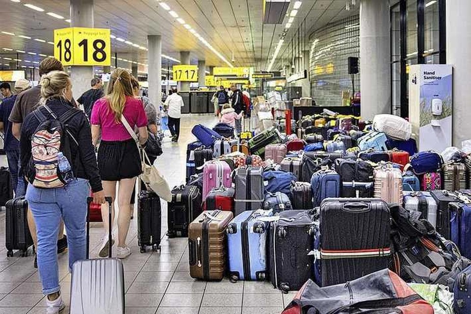 Achtergebleven koffers op Schiphol tussen de bagagebanden afgelopen week. Voor gedupeerde reizigers, die zich zelf door lange wachtrijen moeten worstelen, geen onbekend tafereel. 