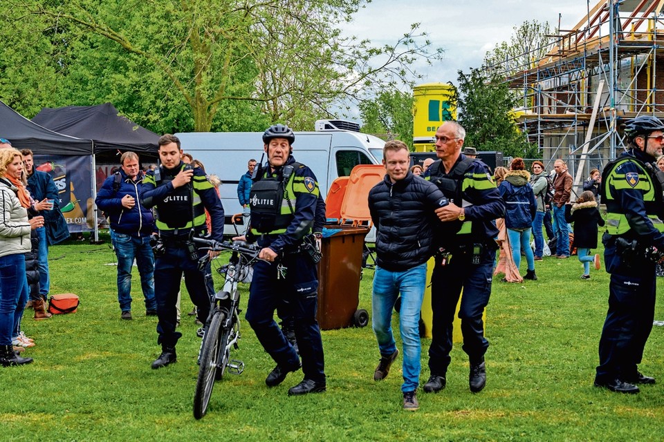 De politie voert Marien Rijkaart af van het feestterrein tijdens Koningsdag in Alphen aan den Rijn. 