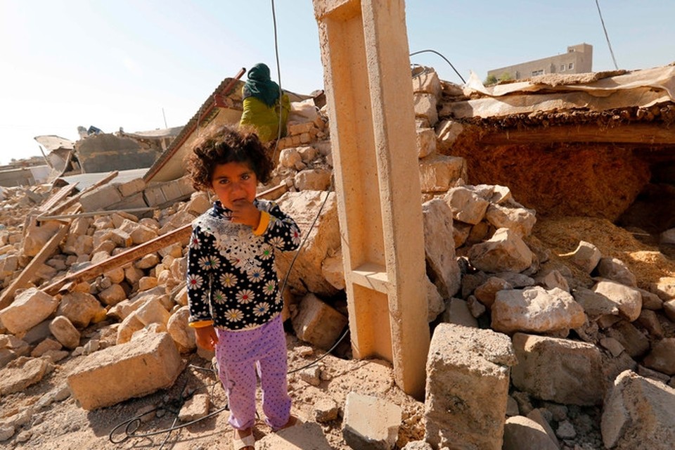 Een Iraans meisje op de puinhopen van haar huis na een zware aardbeving in de provincie Kermanshah bij de grens met Irak in november 2015. Honderden mensen kwamen daarbij om het leven, duizenden raakten dakloos. 