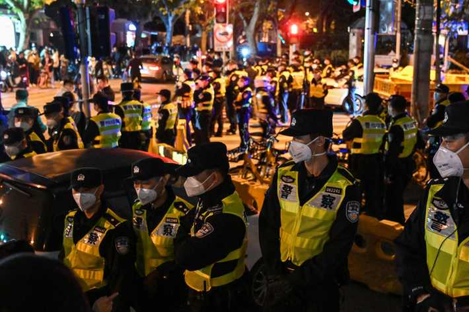 Politieagenten zijn massaal aanwezig bij de protesten in Shanghai. 