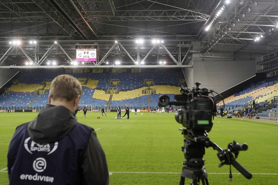 Een cameraman van FOX Sports bij lege tribunes in Arnhem.  