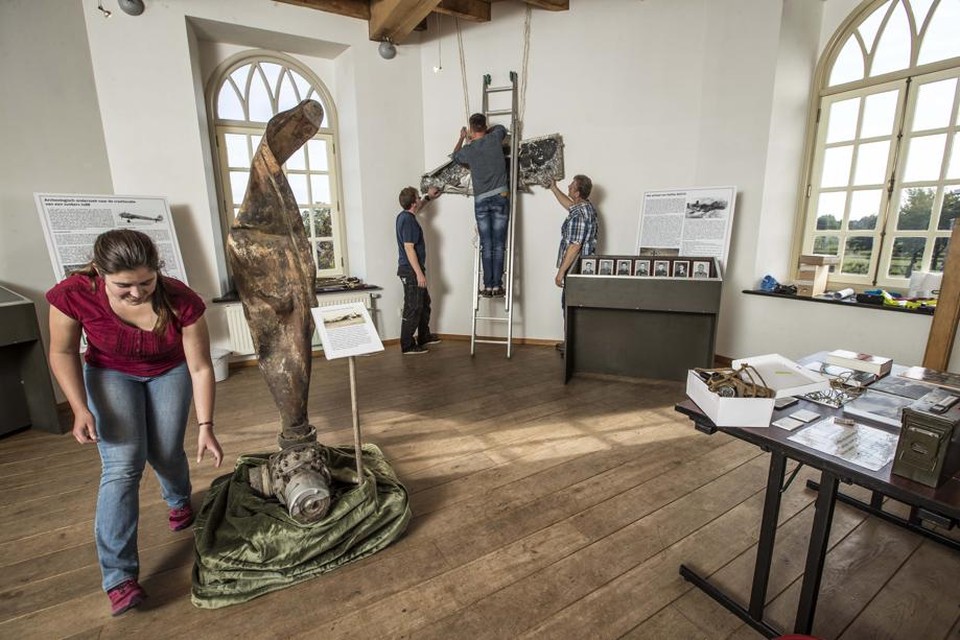 Emma de Boo van Uijen richt met collega’ van de stichting Oorlogserfgoed de expositie in. 