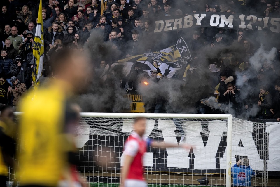 Fans van Roda JC steken vuurwerk af om hun onvrede over de begintijd van de derby tegen MVV te laten blijken. 