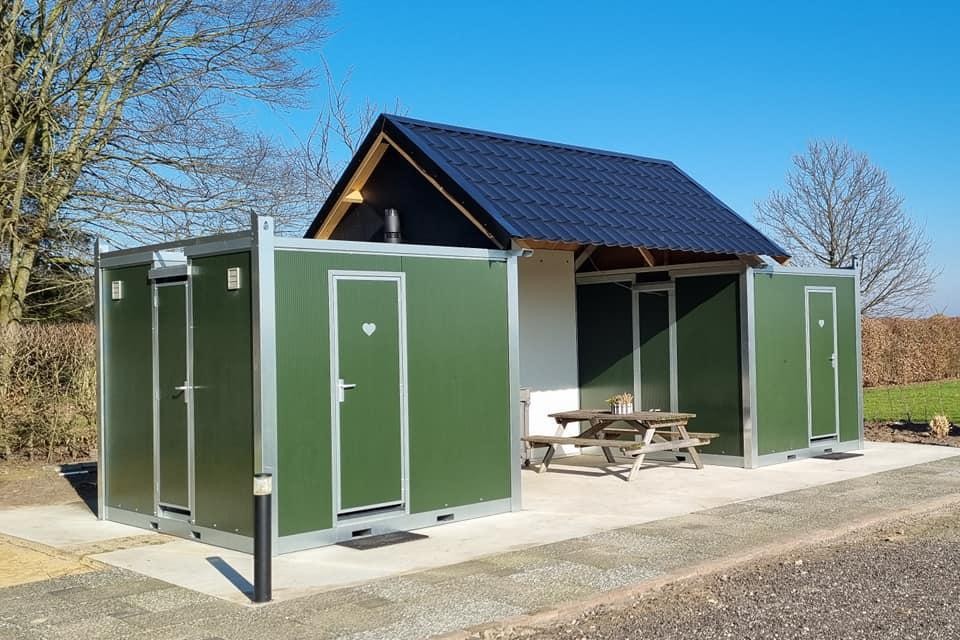 De camperplaats beschikt over twee sanitair-units en een overdekte wasplaats.
