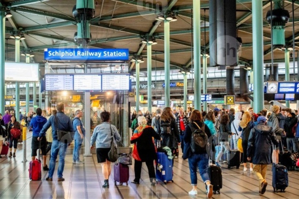 De aankomsthal van treinstation Schiphol waar trein- en luchtreizigers kriskras door elkaar lopen. 