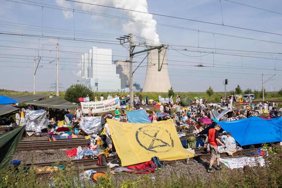 Demonstranten blokkeren een spoorlijn. 