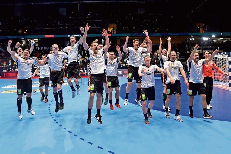 De handballers vieren feest na hun overwinning tegen Letland. 