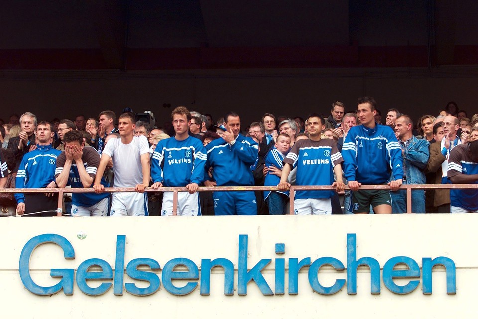 Aangeslagen staan de spelers van Schalke 04 op het bordes van het Parkstadion na het mislopen van de Duitse titel in 2001. Links, met handen voor de ogen, Marco van Hoogdalem. In het midden pinkt coach Huub Stevens een traantje weg. 