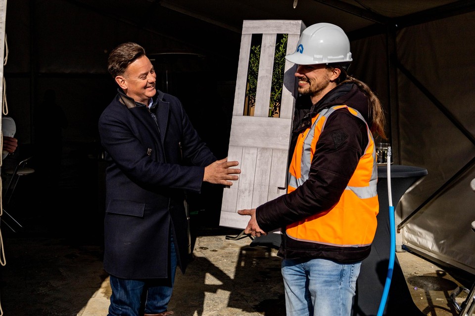 Wethouder Geert Frische overhandigt koper een Kadoboompje als symbool voor de groei van Bloemenhof.