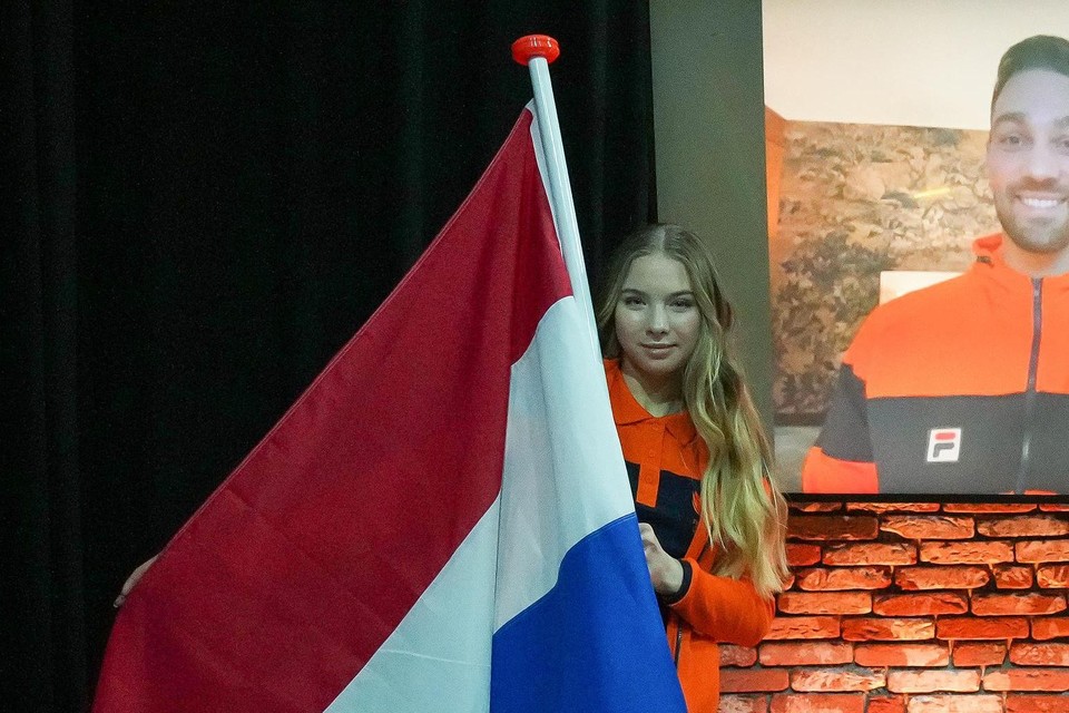 Lindsay van Zundert met de vlag bij de overdracht aan de chef de mission. 