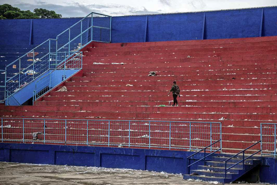 Een man loopt eenzaam op de tribune van het stadion van Arema FC nadat afgelopen weekend een stormloop het leven kostte aan minstens 125 supporters. 