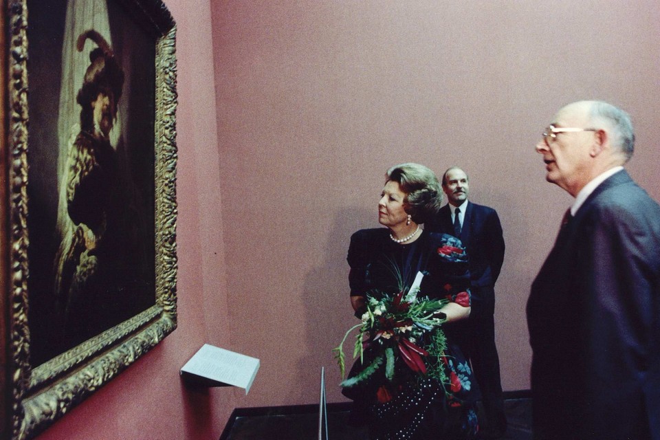 Archiefbeeld: koningin Beatrix kijkt nauwkeurig naar De Vaandeldrager uit 1636 van de Nederlandse schilder Rembrandt.  