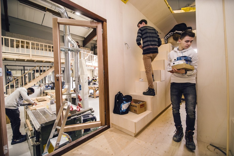 Leerlingen bouwen aan een eenpersoonswoning van 17 vierkante meter in een loods in Beek. 