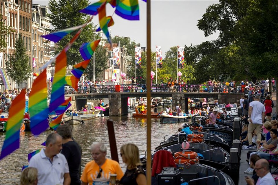 Publiek langs de Prinsengracht in afwachting van de botenparade van de Gay Pride. 