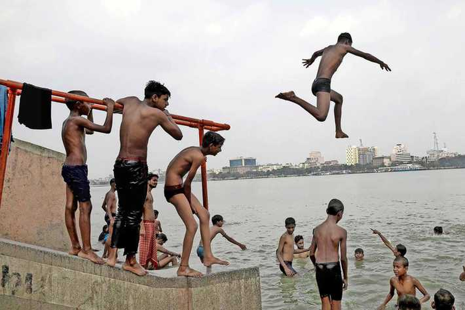Kinderen uit Calcutta zoeken verkoeling in de Hooghly, een zijtak van de Ganges. 