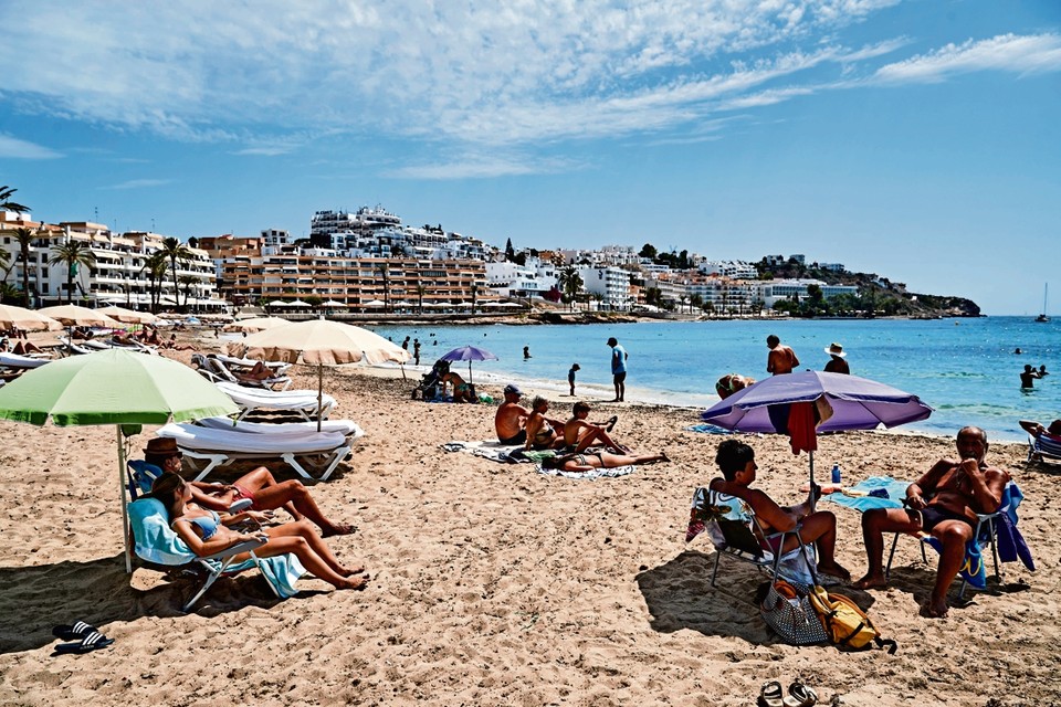 Op de stranden van Ibiza bewaken de badgasten de afstand. Het Spaanse eiland heeft door de toename van het aantal besmettingen de code oranje gekregen. 