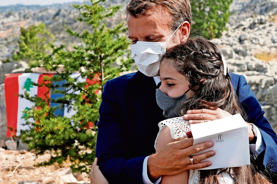 President Macron steunt een slachtoffer van de explosie in Beiroet. 