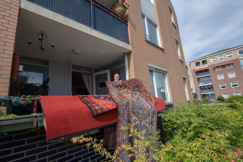 Josef Reichgruber hangt zijn tapijten op het balkon te drogen na de wateroverlast van zondag. 