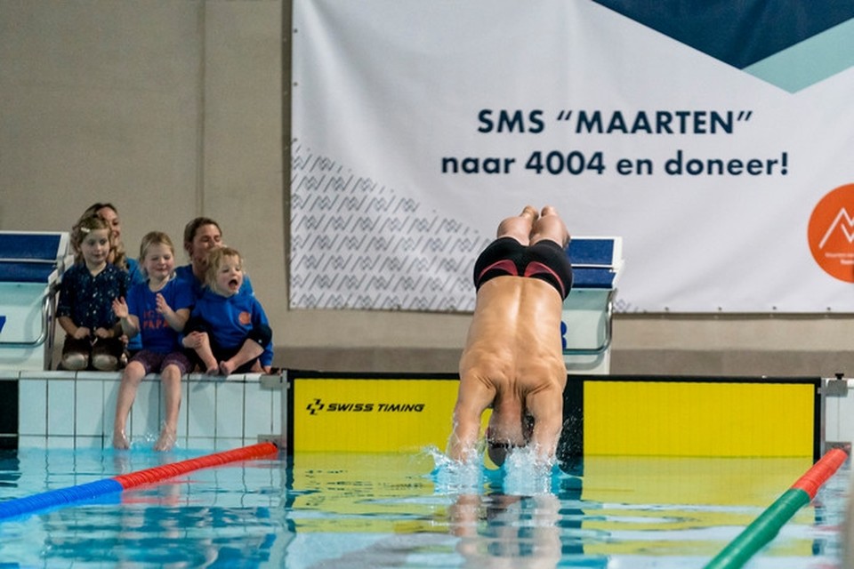 Maarten van der Weijden duikt het water in van Zwembad de Warande in Oosterhout voor zijn recordpoging. 