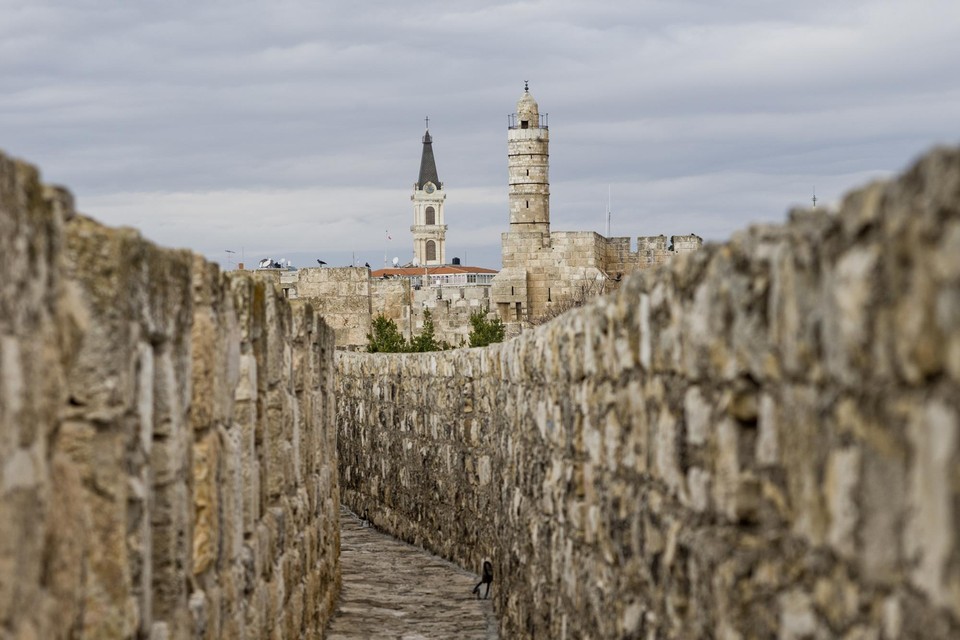 Een ommuurd straatje in Jeruzalem met op de achtergrond de toren van koning David. 