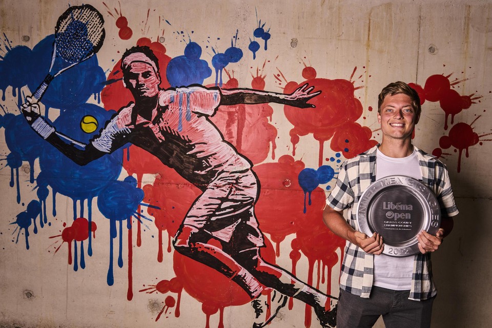 Rosmalen-winnaar Tim van Rijthoven straalt naast een muurschildering van Roger Federer.  