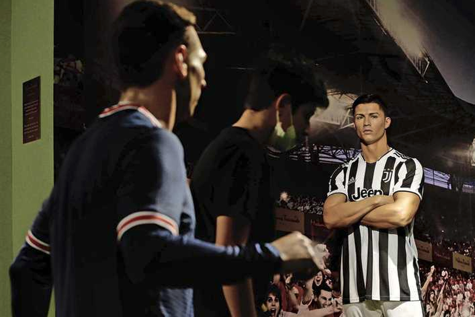 Links Lionel Messi in PSG-shirt, rechts Cristiano Ronaldo in tenue van Juventus. 