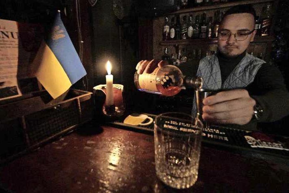 Een barman in Kiev schenkt nog maar eens een glas in tijdens één van vele stroomonderbrekingen in de hoofdstad. 