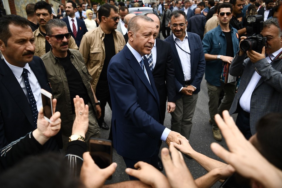 Erdogan begroet aanhangers bij het stembureau.