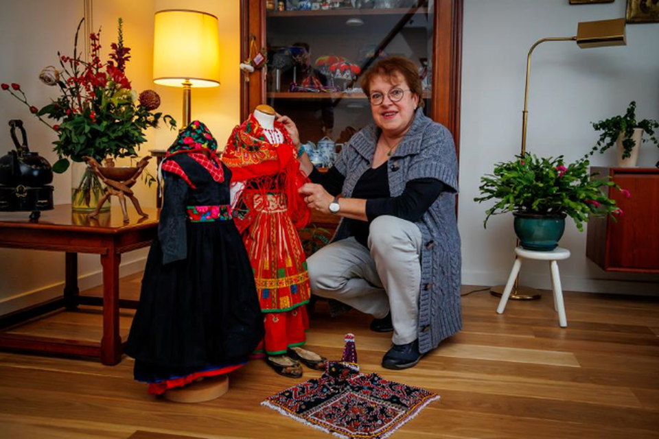 Monique Derwig verzamelt kinderkleding vanuit de hele wereld. Links klederdracht uit Staphorst. 