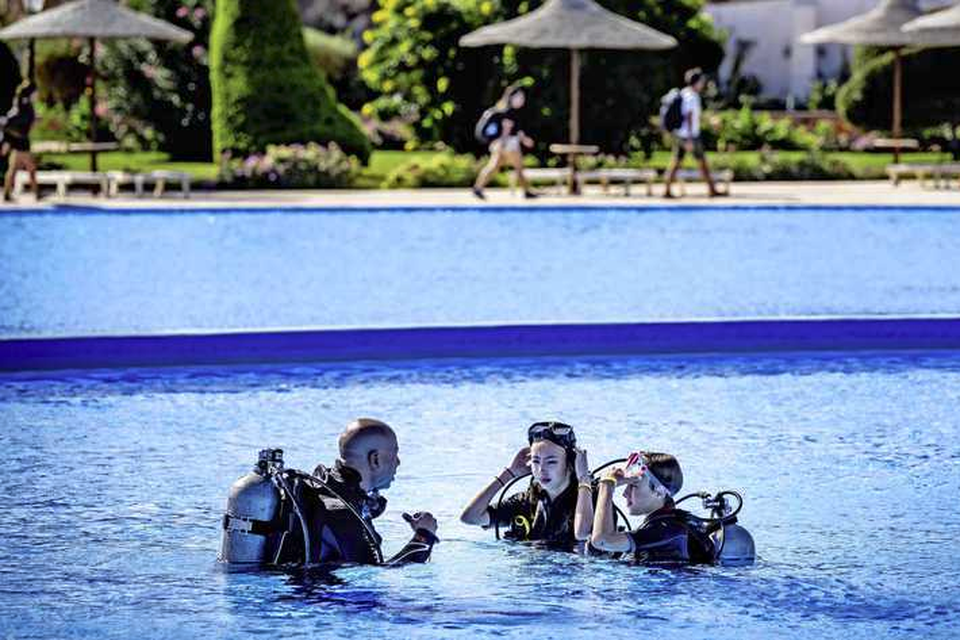 Duikles van een duikinstructeur in een Egyptisch zwembad. Nederlanders blijven reizen, maar zijn wel prijsbewuster.