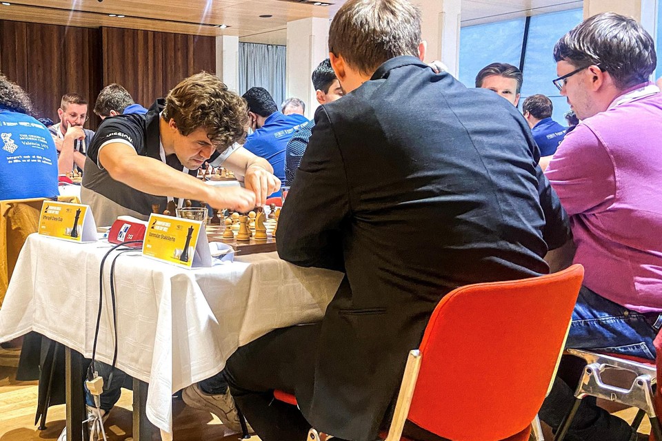 In een uithoek van de zaal -waar de speeltafels op elkaar gepropt staan- weet Magnus Carlsen niet te winnen van Nikita Meshkovs, de Letse nummer 330 van de wereldranglijst. 