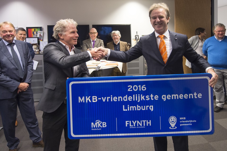 Burgemeester Wil Houben (rechts) neemt het bord in ontvangst dat hoort bij de prijs van MKB-vriendelijkste gemeente van Limburg.