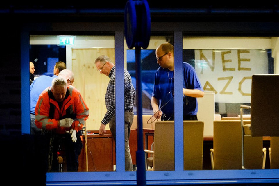 Bij het gemeentehuis van Geldermalsen wordt de schade gerepareerd, die is ontstaan nadat rellen uitbraken terwijl de raad bijeen was om een besluit te nemen over de komst van een azc.