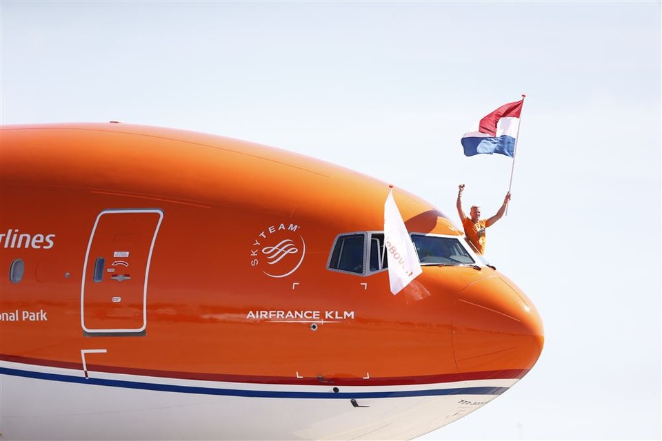 Zwemmer Ferry Weertman houdt de vlag vast tijdens de landing van het vliegtuig met de olympische medaillewinnaars van TeamNL op luchthaven Schiphol. 