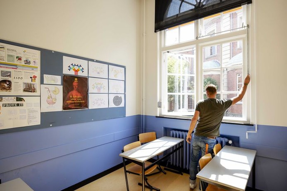 Een leraar van Atheneum College Hageveld zet de ramen open tijdens de voorbereidingen voor het begin van het nieuwe schooljaar. 